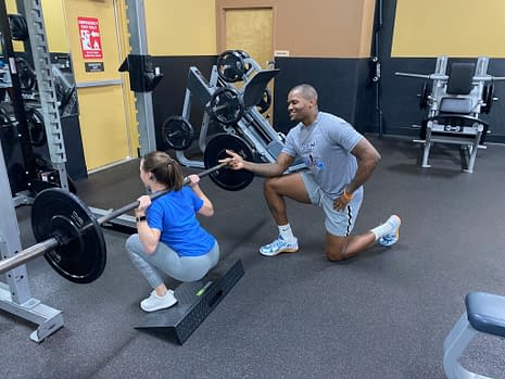 personal trainer teaching squats